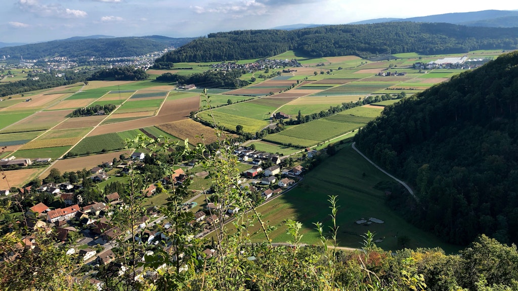 Landschaft mit Feldern, Hügeln und Dorf