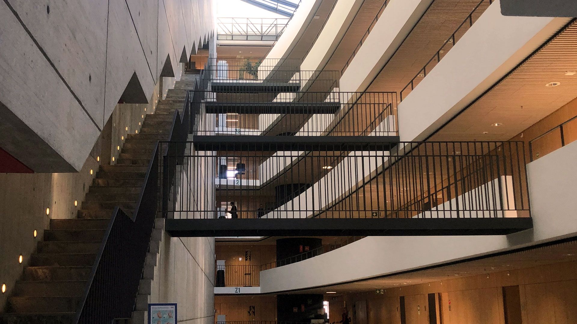 Une vue intérieure du bâtiment avec vue sur le haut et les nombreux étages, escaliers et ponts.