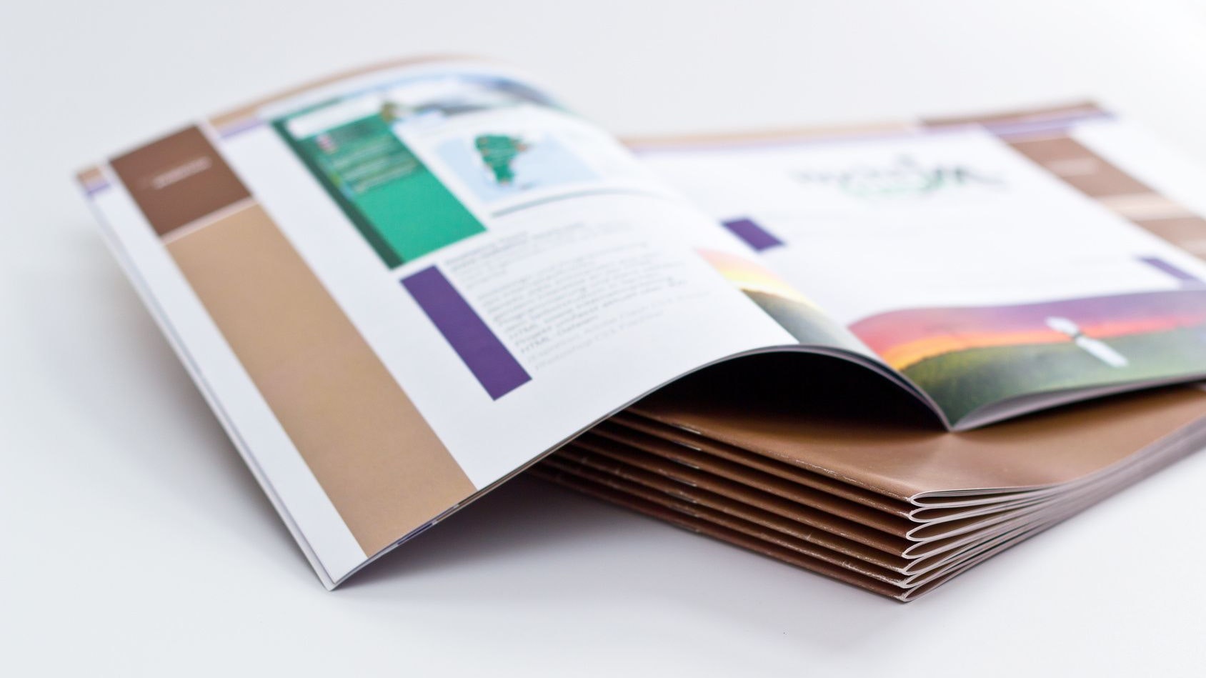 Des publications empilées. La publication du dessus est ouverte sur une double page.