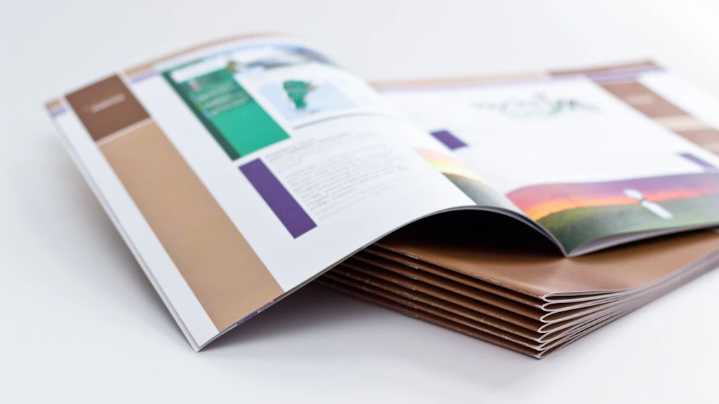 Des publications empilées. La publication du dessus est ouverte sur une double page.