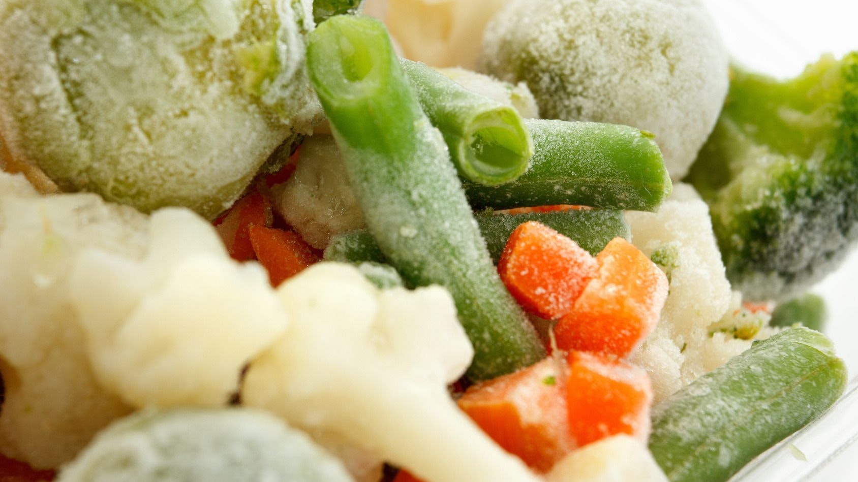Légumes congelés, en petits morceaux, couverts d’une fine couche de givre.
