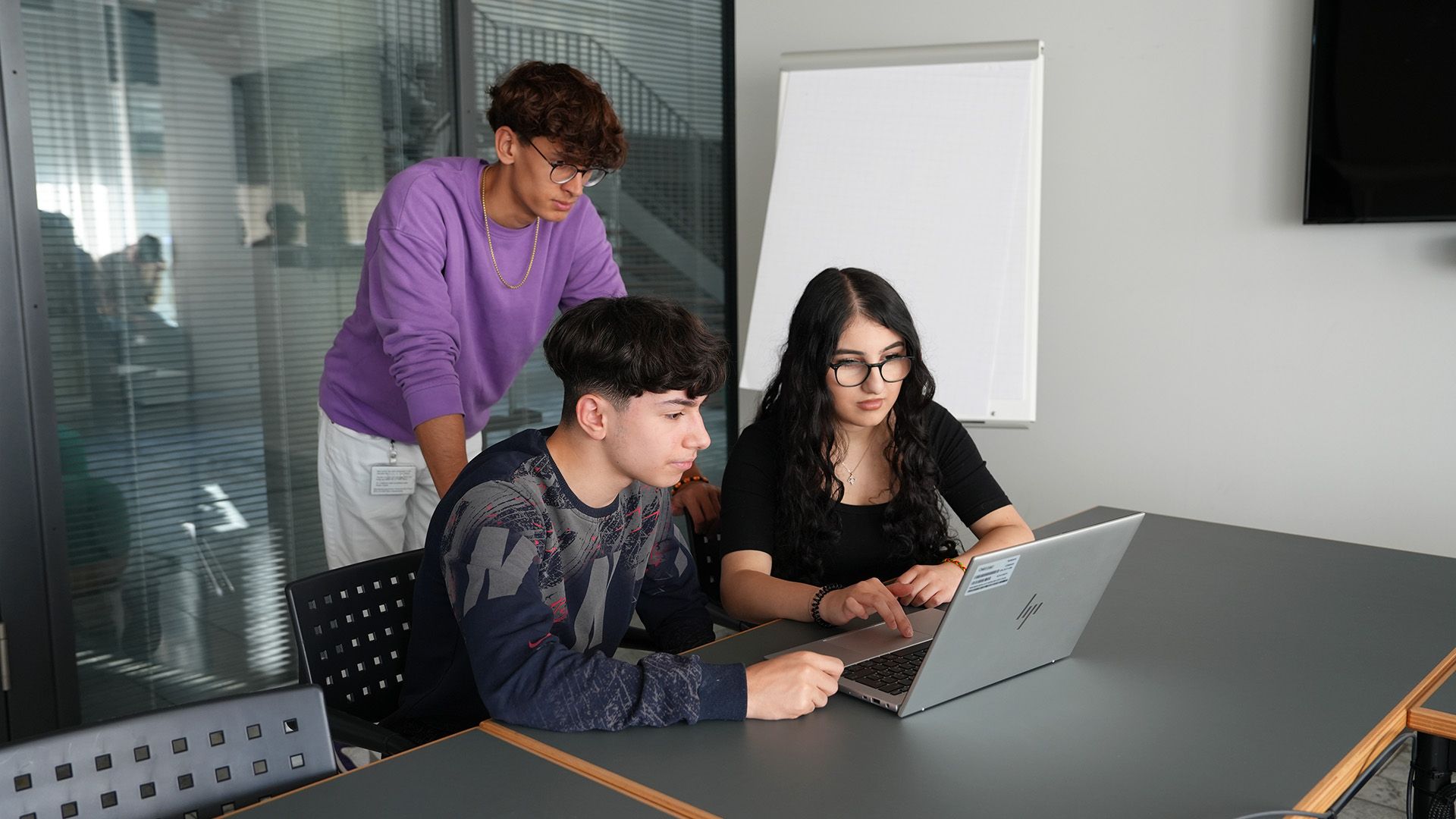 Tre studenti che lavorano insieme su un laptop