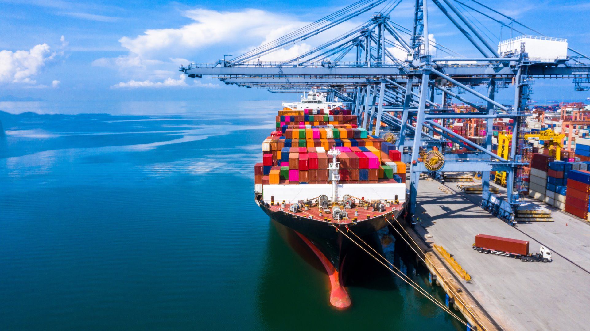 Una nave da carico attraccata con container colorati nel porto di carico.