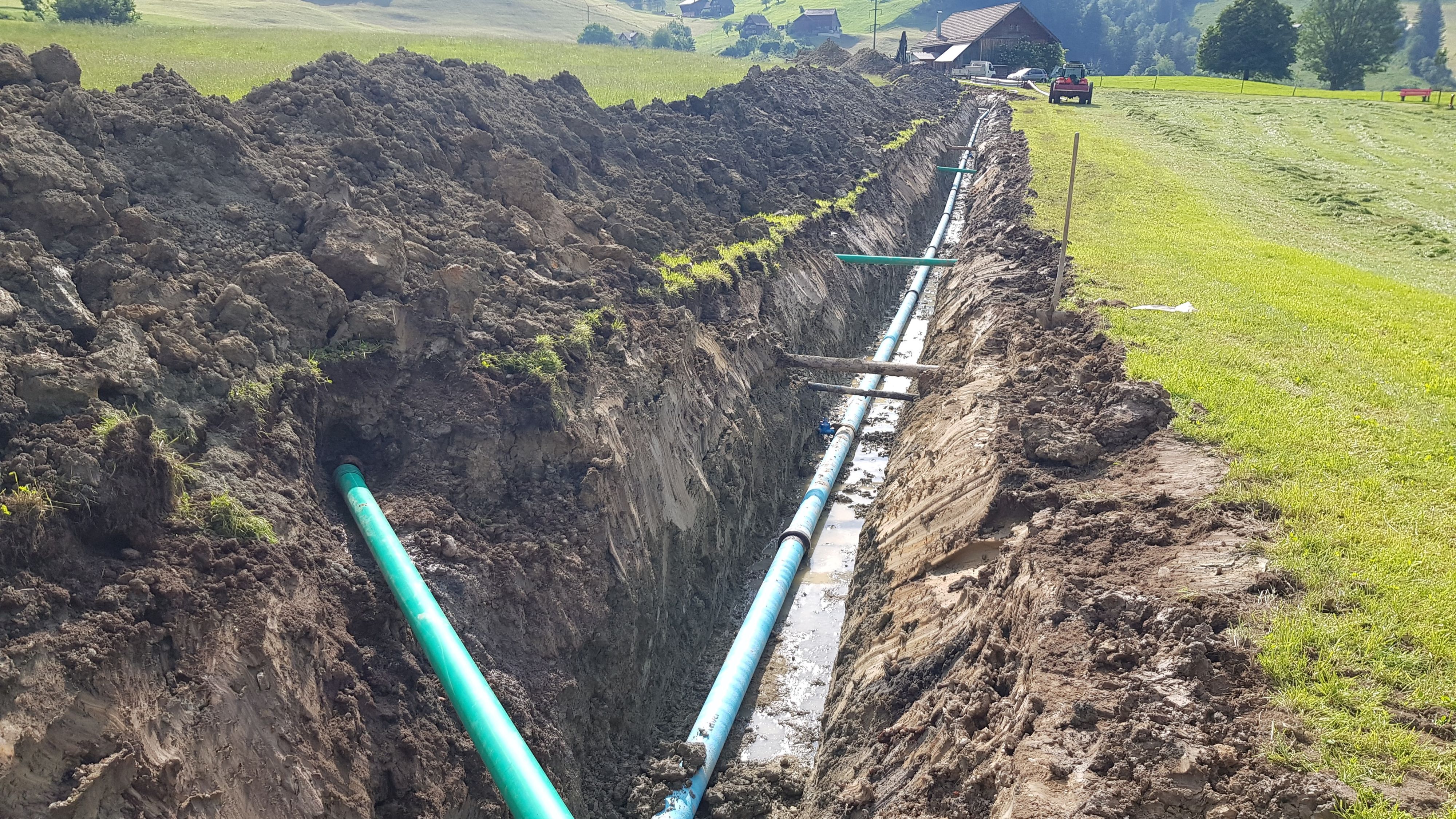 Lungo canale aperto in un prato con tubo di condotta.